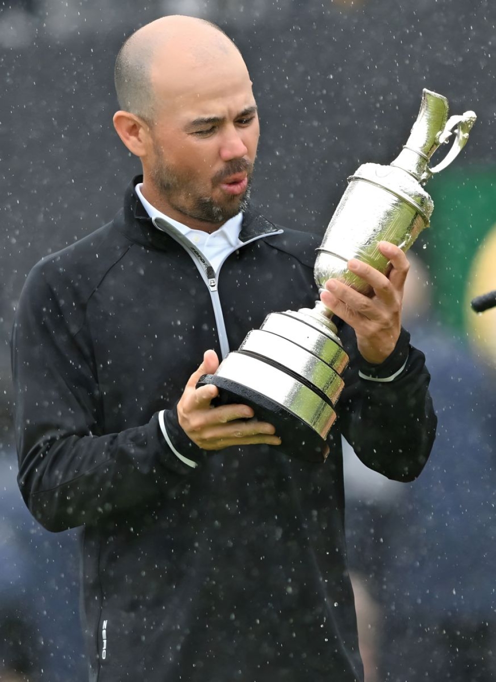 Our cover picture. I’ve done it! Open Champion Brian Harman savours his moment of victory and cradles the Claret Jug oblivious to the heavy rain. He led after a brilliant 66 in windy conditions on day two and never relinquished the lead. His victory was underpinned by one of the best putting performances ever seen at a major, holing 59 out of 60 putts from 10 feet which included 14/15 from 5ft to 10ft and 35/35 under 5ft.  To put it another way, he gained 11.57 strokes on the field in putting, and his stats confirm the quality of the Hoylake greens during the 151st Open. Just as impressive was the fact that Harman visited only two bunkers all week, and one of those was on the 72nd hole!
