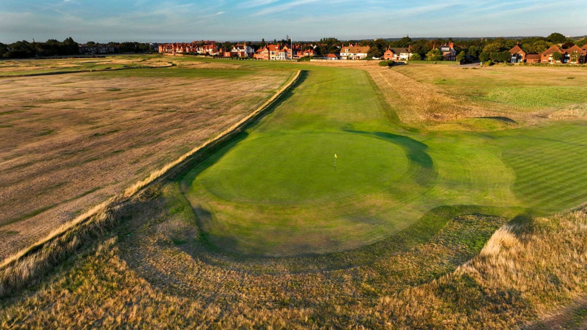 With a tee shot flanked by out of bounds on one side and the clubhouse on the other, this is an extremely challenging first which requires accuracy and courage. A sharp dog leg to the right demands a well positioned drive as near to the corner of the practice ground as confidence will allow. The second shot might be some 190 yards to a green protected by a swale on the safer left side away from the out of bounds close on the right.